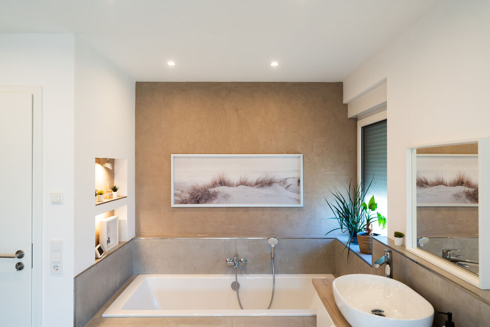 Badezimmer mit fugenlosem Putz an Wand und Badewannenverkleidung